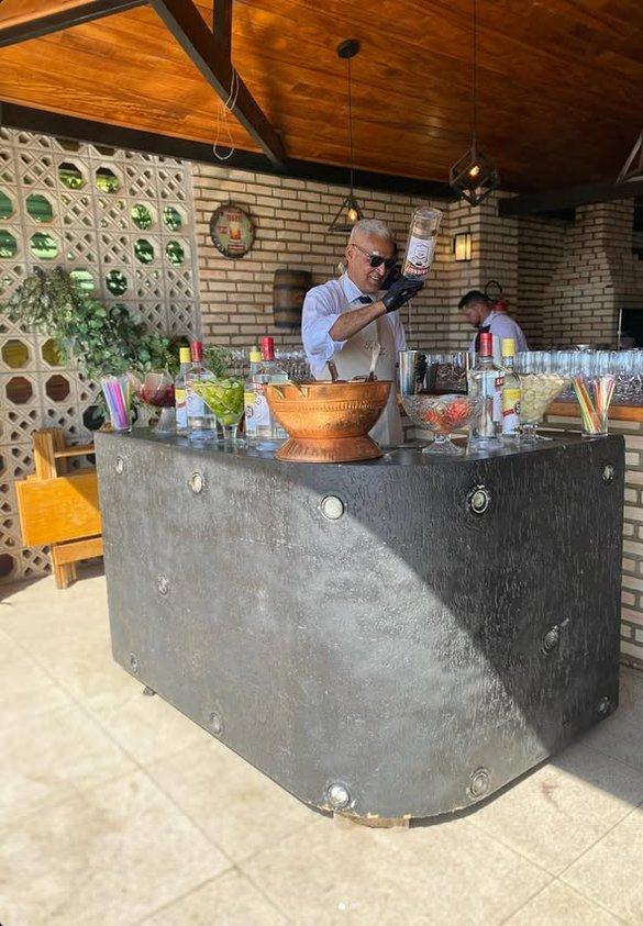 Bartender da equipe preparando drinks no bar de eventos